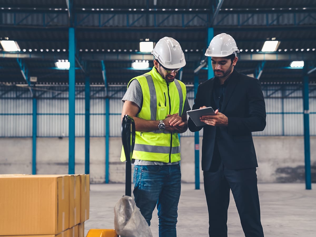 A site manager checking in a contractor at a plant entrance